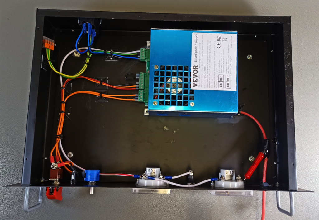 Top-view of the high-voltage power supply and its internal wiring around the VEVOR laser power supply